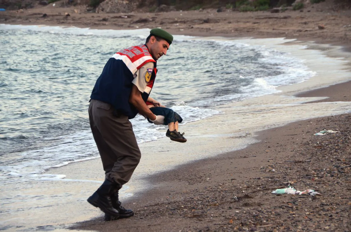 ADDS IDENTIFICATION OF CHILD A paramilitary police officer carries the lifeless body of Aylan Kurdi, 3, after a number of migrants died and a smaller number were reported missing after boats carrying them to the Greek island of Kos capsized, near the Turkish resort of Bodrum early Wednesday, Sept. 2, 2015. The family — Abdullah, his wife Rehan and their two boys, 3-year-old Aylan and 5-year-old Galip — embarked on the perilous boat journey only after their bid to move to Canada was rejected. The tides also washed up the bodies of Rehan and Galip on Turkey's Bodrum peninsula Wednesday, Abdullah survived the tragedy. (AP Photo/DHA) TURKEY OUT