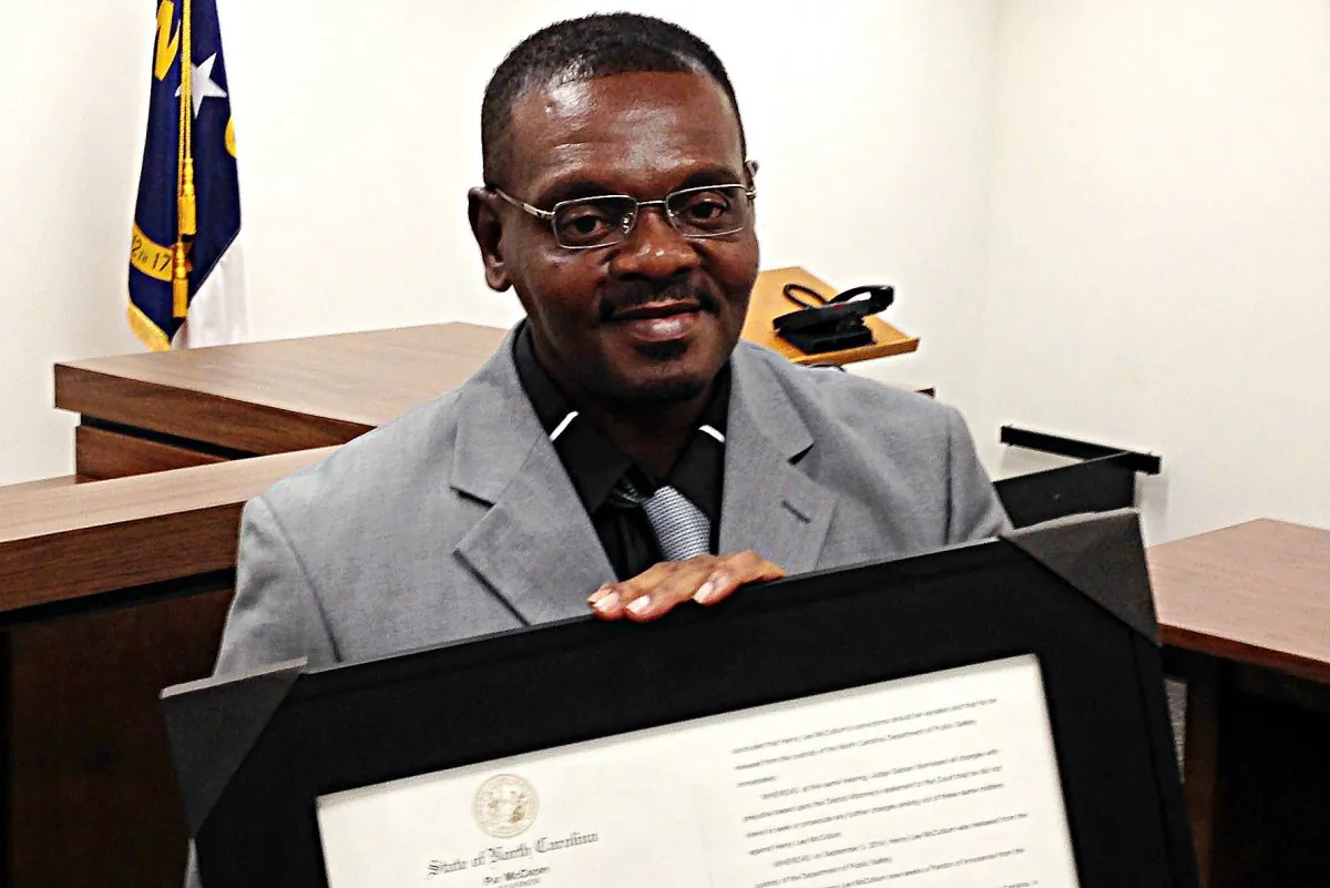 Henry McCollum holds a framed copy of his pardon before a hearing on compensation by the state for his wrongful conviction on Sept. 2, 2015 in Raleigh, N.C. (AP Photo/Jonathan Drew)