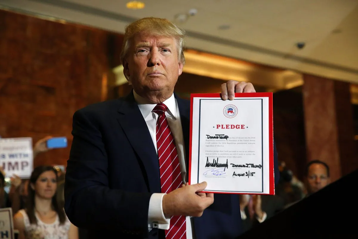Donald Trump holds up a pledge at a news conference in Manhattan after he signed the pledge Thursday to support the Republican nominee in the 2016 general election, ruling out a third-party or independent run on September 3, 2015 in New York City. Trump made the announcement following a meeting with Republican National Committee chairman Reince Priebus. Trump stressed repeatedly in the news conference that he is leading in all national polls. (Photo by Spencer Platt/Getty Images)