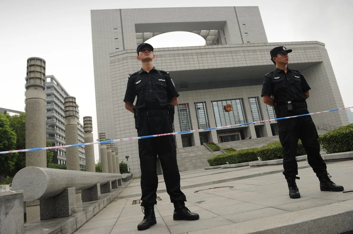 Policemen stand guard outside the Intermediate People's Court in Hefei, Anhui Province on Aug. 10, 2012. (Peter Parks/AFP/Getty Images)