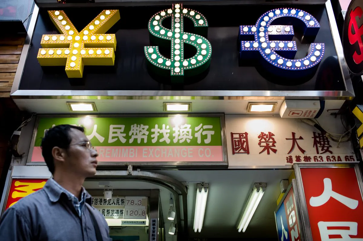 A man walks past a money exchange booth in Hong Kong, October 25, 2013 (PHILIPPE LOPEZ/AFP/Getty Images)