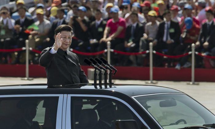 leader of the Communist Party Xi Jinping rides in an open top car as he greets soldiers and others in front of Tiananmen Square and the Forbidden City during a military parade on Sept. 3, 2015 in Beijing, China. Observers were surprised when former regime leader Jiang Zemin showed up on the reviewing stand with Xi.  (Kevin Frayer/Getty Images)