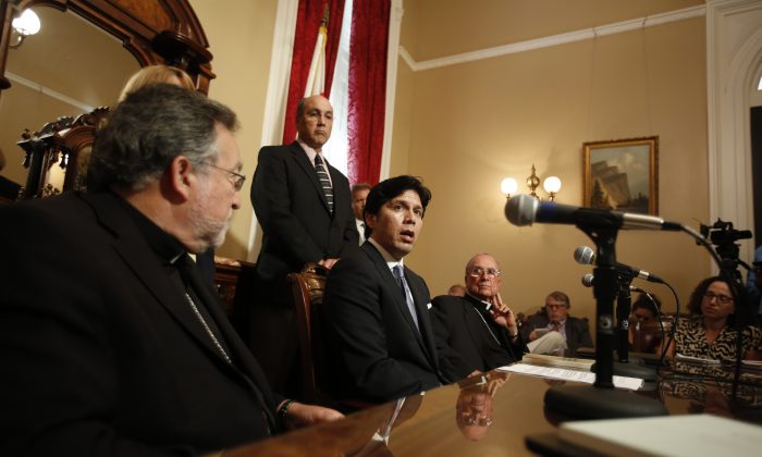 In this photo taken Monday, Aug. 31, 2015, Senate President Pro Tem Kevin de Leon, D- Los Angeles, seated center, talks with reporters about climate change during a news conference with Bishop Jaime Soto of the Sacramento Catholic Dioceses, seated left and Bishop Stephen Blaire of the Stockton Diocese, seated right in Sacramento, Calif.  Gov. Jerry Brown and Democratic leaders are locked in a late-hour battle against oil companies to secure ambitious climate change legislation for California. (AP Photo/Rich Pedroncelli)