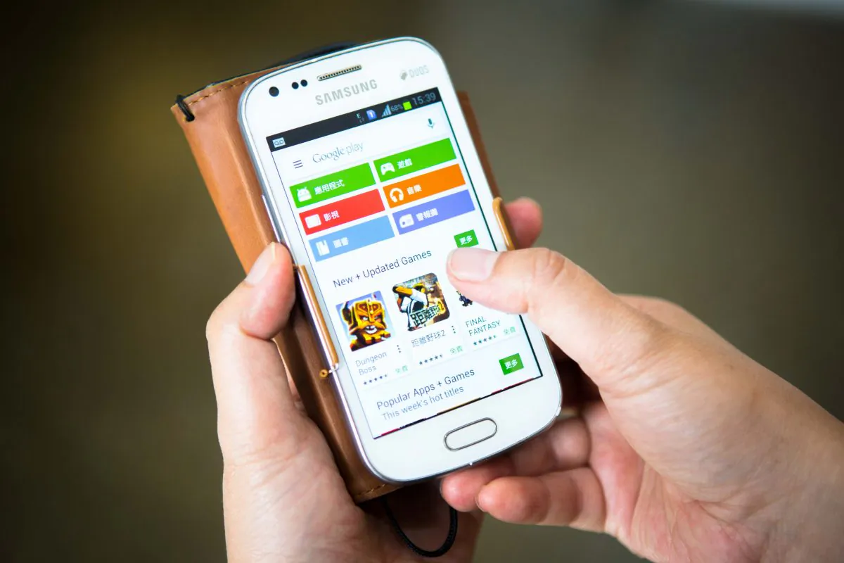 A woman navigates through the Google Play store in Chinese on her Smartphone in New York on Sept. 6. (Benjamin Chasteen/Epoch Times)
