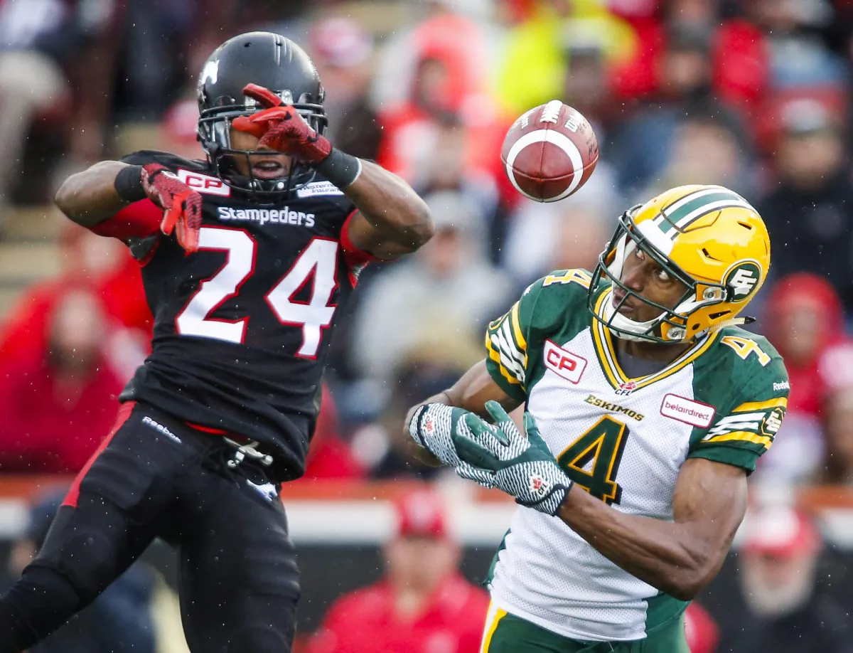 Edmonton Eskimos' Adarius Bowman (R) juggles a pass as Calgary Stampeders' Joe Burnett looks on at McMahon Stadium in Calgary on Sept. 7. (The Canadian Press/Jeff McIntosh)