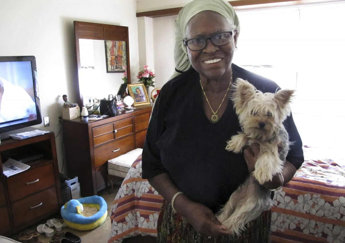 In this Tuesday, Aug. 25, 2015 photo, Bonnie Jean Cook holds her therapy dog, Bella, in her apartment in East Hartford, Conn. (AP Photo/Dave Collins)