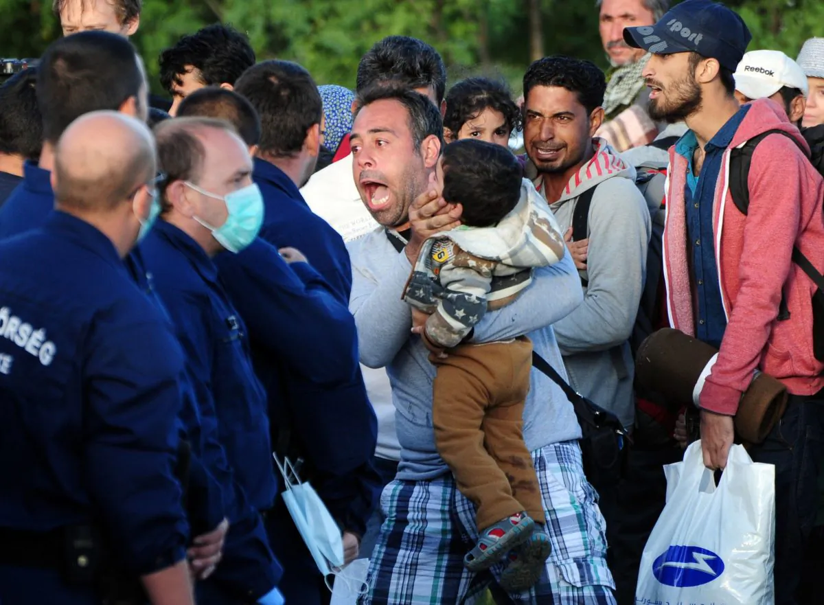 Migrants are stopped by police after the group broke out from a collection point near Roszke village at the Hungarian-Serbian border on September 7, 2015. (CSABA SEGESVARI/AFP/Getty Images)