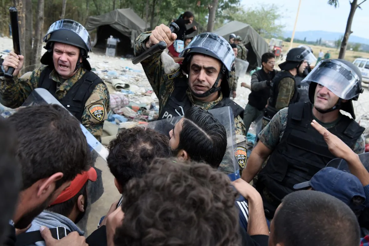 FUROM policemen scuffle with refugees and migrants as they wait to pass the borders from the northern Greek village of Idomeni, to southern FYROM, Monday, Sept. 7, 2015. (AP Photo/Giannis Papanikos)