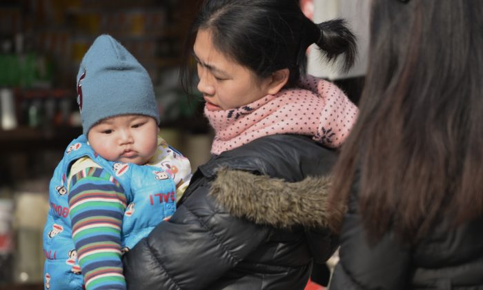 A mother carries her baby on a street in Shanghai in this file photo. (Peter Parks/AFP/Getty Images)