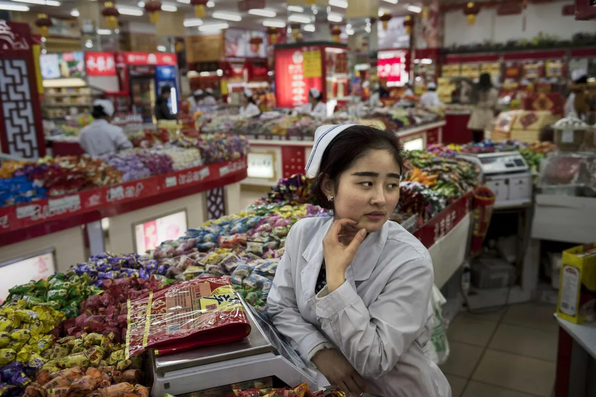 A Chinese worker waits for customers at a grocery store on January 20, 2015 in central Beijing, China. (Kevin Frayer/Getty Images)