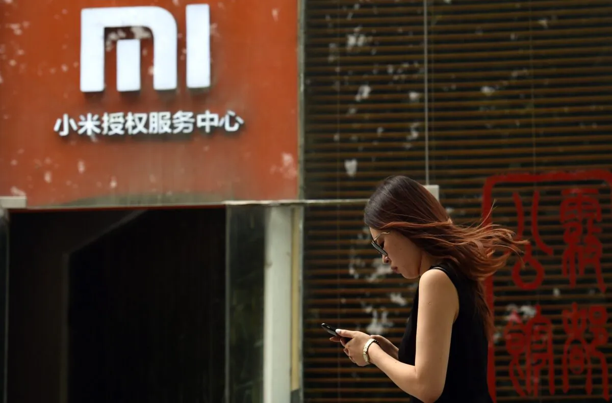 A woman walks past a Xiaomi logo outside a Xiaomi service center in Beijing, China, on Aug. 5, 2015. (Greg Baker/AFP/Getty Images)
