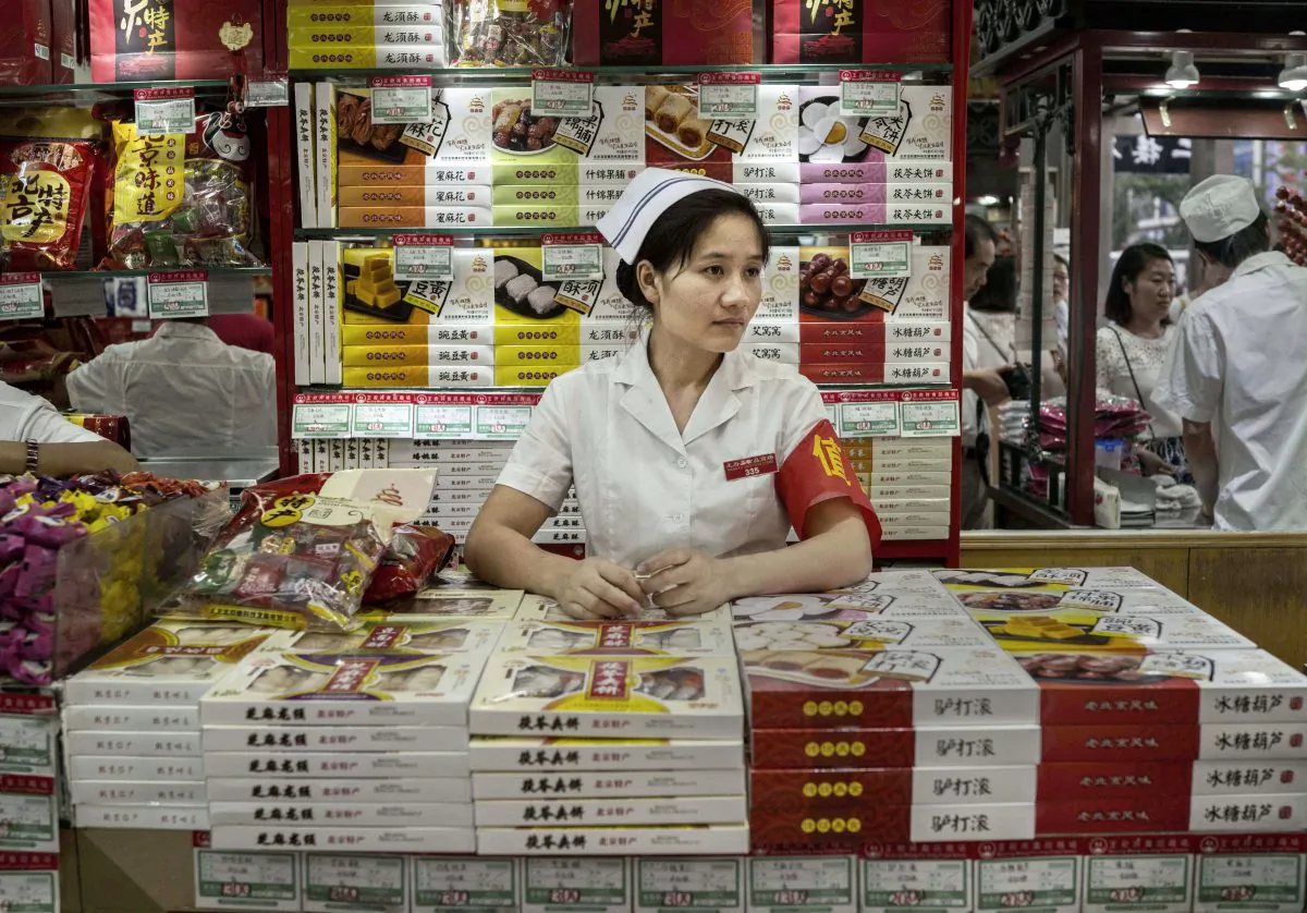 A Chinese retail clerk waits for customers at a shop on August 28, 2015 in Beijing, China. (Kevin Frayer/Getty Images)
