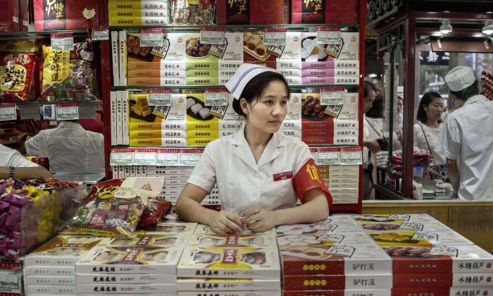 A Chinese retail clerk waits for customers at a shop on August 28, 2015 in Beijing, China. (Kevin Frayer/Getty Images)