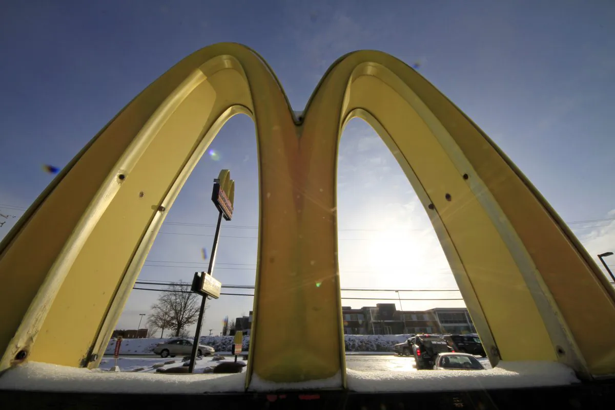 Cars drive past the McDonald's Golden Arches logo at a McDonald's restaurant in Robinson Township, Pa., on Jan. 21, 2014. (AP Photo/Gene J. Puskar)