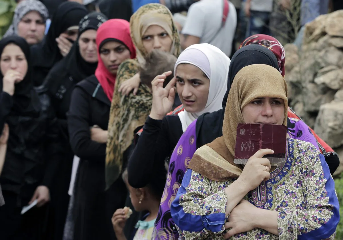 Syrian women wait in line to receive aid from an Islamic relief agency at a refugee camp in the town of Ketermaya, north of the port city of Sidon, Lebanon on Sept. 7, 2015 file photo. (AP Photo/Bilal Hussein)