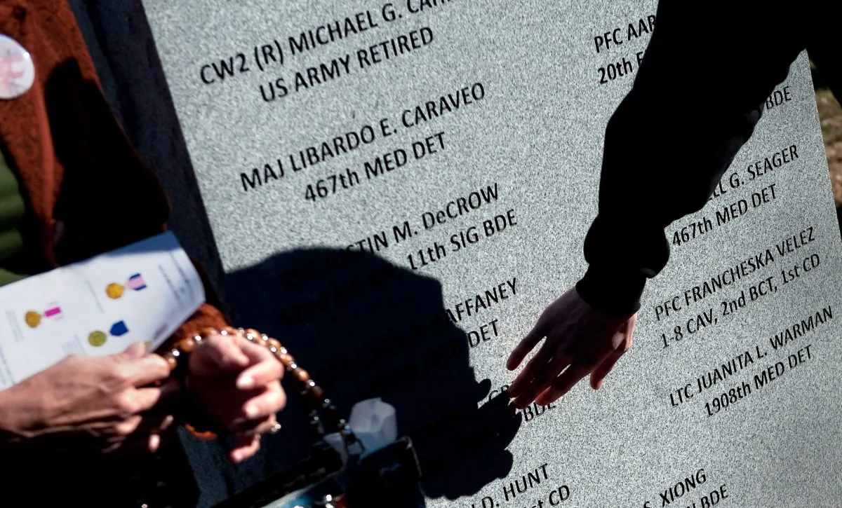 Family members and friends visit a memorial stone after it was unveiled during a Nov. 5, 2010, ceremony commemorating the one-year anniversary of the shootings on Fort Hood, Texas. (D. Myles Cullen/U.S. Department of Defense)