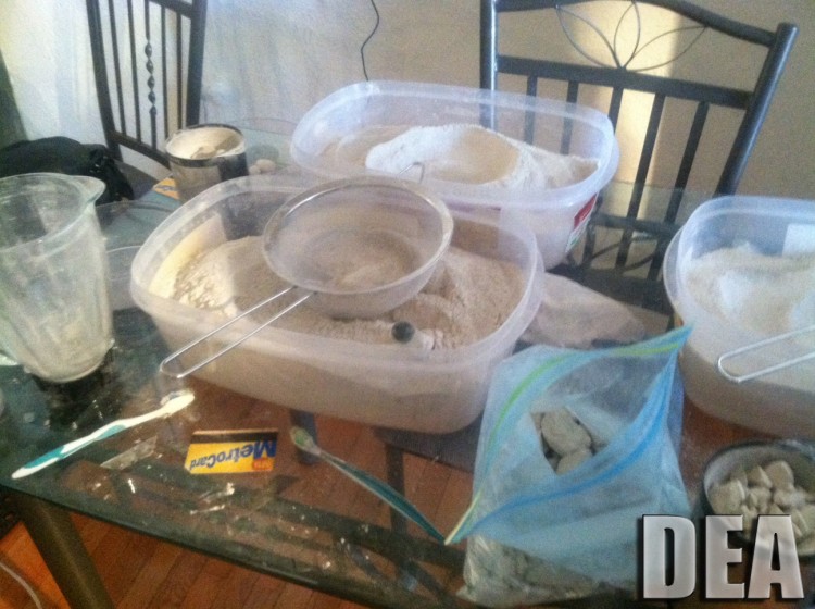 Heroin seen in containers with a foundation of a grinder, a sifter, and other drug selling tools. (DEA) Heroin seen in containers with a foundation of a grinder, a sifter, and other drug selling tools. (DEA)