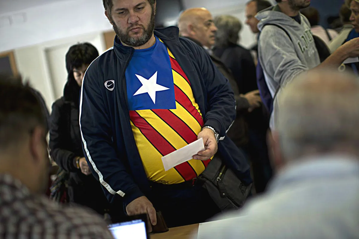 Carlas Albert, 45, waits to cast his vote for an informal independence poll in a polling station in Barcelona, Spain, on Sunday Nov.9, 2014. (AP Photo/Emilio Morenatti)