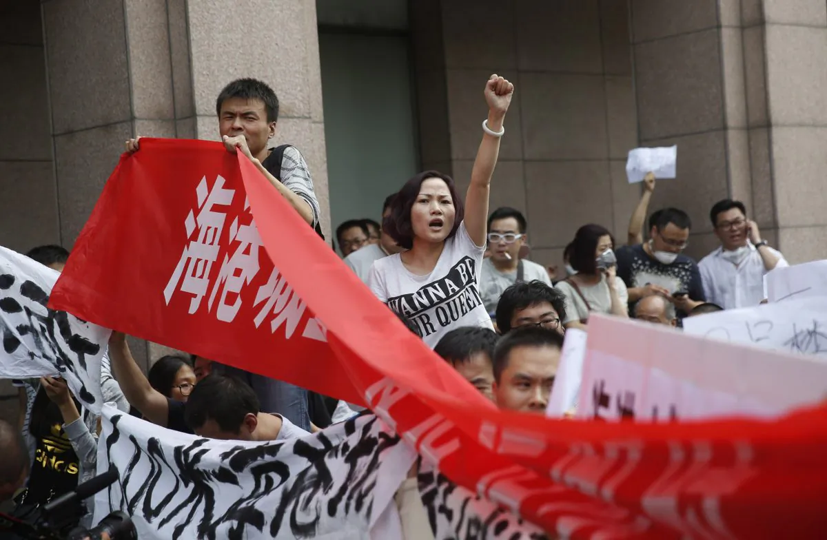 Chinese residents protest outside the hotel where authorities held a press conference in Tianjin, after a massive chemical explosion there, on Aug. 17, 2015. (STR/AFP/Getty Images)
