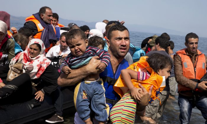 Syrian refugees arrive aboard a dinghy after crossing from Turkey to the island of Lesbos, Greece, on Sept. 10, 2015. (AP Photo/Petros Giannakouris)