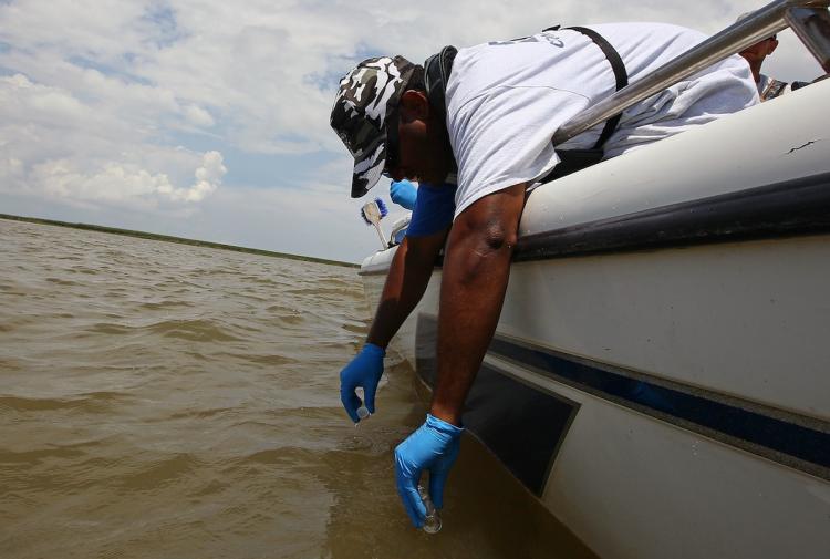TESTING THE WATERS: Environmental Protection Agency contractor Larry Howard collects water samples for testing near the point where the South Pass of the Mississippi River meets the Gulf of Mexico in Louisiana. (Win McNamee/Getty Images) TESTING THE WATERS: Environmental Protection Agency contractor Larry Howard collects water samples for testing near the point where the South Pass of the Mississippi River meets the Gulf of Mexico in Louisiana. (Win McNamee/Getty Images)