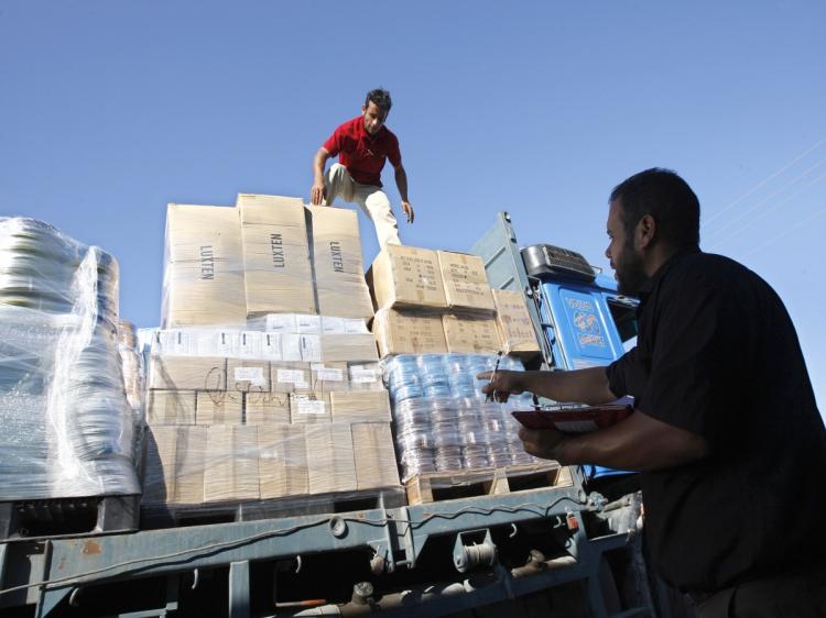 Palestinian workers inspect trucks carrying supplies after it arrived in Rafah town through the Kerem Shalom crossing between Israel and the southern Gaza Strip on July 06, 2010, as Israel gave the go-ahead for the international community to import construction materials into the Hamas-run Gaza Strip in an easing of its blockade that won cautious praise. (Said Khatib/AFP/Getty Images)