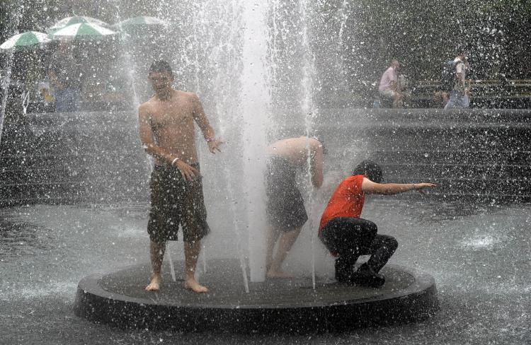 Three boys stand in the middle of the fountain in Washington Square Park in New York, July 8. A heat wave with record temperatures rolled across the eastern United States, pushing power companies to the limit and driving residents to municipal 'cooling centers.' (Timothy A. Clary/Getty Images )