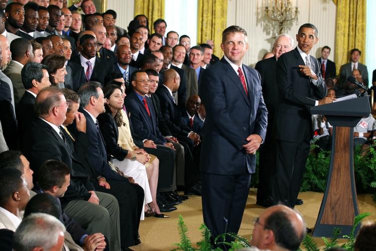 President Barack Obama speaks as team owner Tom Benson (2nd R) and head coach of the New Orleans Saints Sean Payton (3rd R) listens as he hosts a reception for the 2010 National Football League Super Bowl champions in the East Room of the White House August 9, in Washington, DC. (Alex Wong/Getty Images)