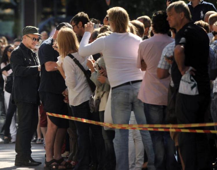Bono (L), lead singer of Irish rock band U2 signs autographs for fans outside the Hotel Kamp in Helsinki, Finland on Aug. 20, 2010.  (Petra Piitulainen/AFP/Getty Images )