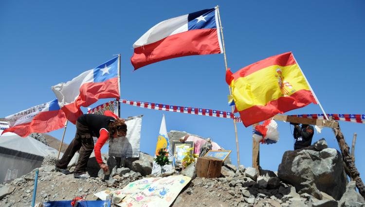 A relative of one of the 33 miners trapped in the San Jose mine, places a Spanish flag given by Spanish tourists beside several Chilean ones, near Copiapo, 800 km north of Santiago, September 13. (Ariel Marinkovic/Getty IMages) A relative of one of the 33 miners trapped in the San Jose mine, places a Spanish flag given by Spanish tourists beside several Chilean ones, near Copiapo, 800 km north of Santiago, September 13. (Ariel Marinkovic/Getty IMages)