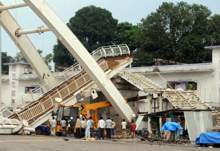 COLLAPSE: Indian workers gather after a collapsed footbridge at the Jawaharlal Stadium in New Delhi on Sept. 21, the main venue for the forthcoming Commonwealth Games. The games are set to begin Oct. 3. (Raveendran/Getty Images ) COLLAPSE: Indian workers gather after a collapsed footbridge at the Jawaharlal Stadium in New Delhi on Sept. 21, the main venue for the forthcoming Commonwealth Games. The games are set to begin Oct. 3. (Raveendran/Getty Images )