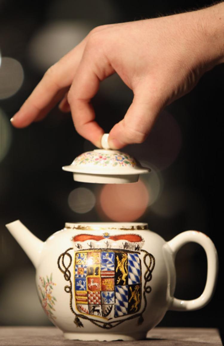 A Bonhams employee lifts the lid on a porcelain teapot dated 1713-14, at Bonhams Auction house on November 22, 2010 in London, England. ( Dan Kitwood/Getty Images) A Bonhams employee lifts the lid on a porcelain teapot dated 1713-14, at Bonhams Auction house on November 22, 2010 in London, England. ( Dan Kitwood/Getty Images)