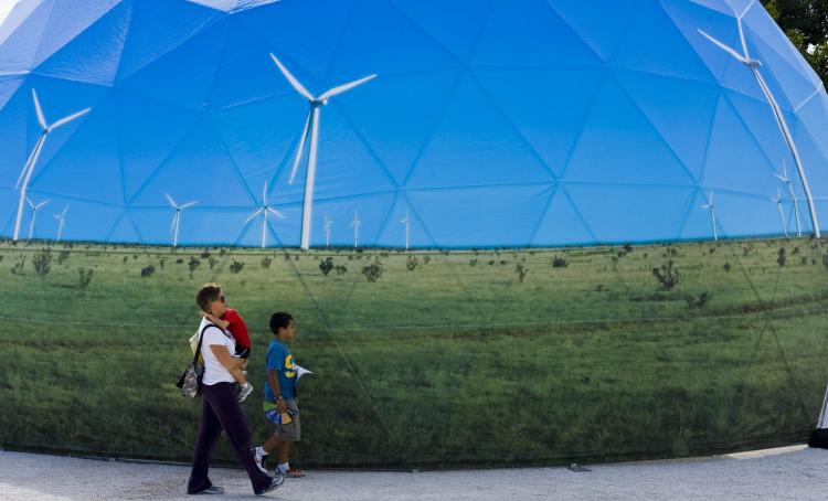 A family passes by one of the stands promoting green energy at the Climate Village in Cancun, Mexico, on Dec. 4. (Omar Torres/AFP/Getty Images) A family passes by one of the stands promoting green energy at the Climate Village in Cancun, Mexico, on Dec. 4. (Omar Torres/AFP/Getty Images)