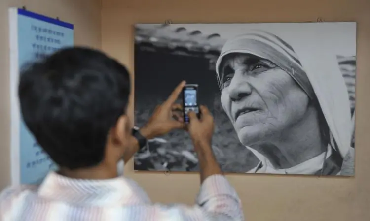A boy takes a picture of an image of Mother Teresa that hangs in a carriage of the "Mother Express" train in Mumbai. Research has found that witnessing extraordinary acts of compassion inspire others to do good in their own lives. (Sajjad Hussain/AFP/Getty Images)
