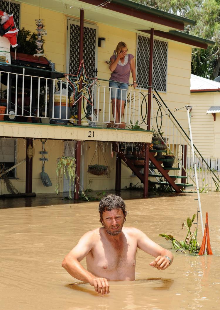 Australia floods: Gary Russell (front) waits for his wife Robyn (top) and dogs to be evacuated by emergency personnel from their flood affected home in Rockhampton on Jan. 6, 2011. (Torsten Blackwood/AFP/Getty Images) Australia floods: Gary Russell (front) waits for his wife Robyn (top) and dogs to be evacuated by emergency personnel from their flood affected home in Rockhampton on Jan. 6, 2011. (Torsten Blackwood/AFP/Getty Images)
