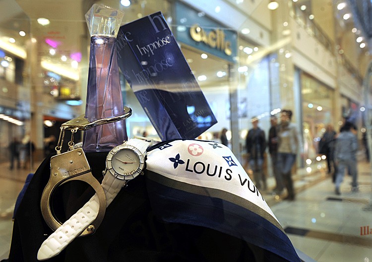 LANDMARK CASE: A counterfeit Louis Vuitton scarf, Lancome perfume, and Chopard wristwatch are displayed at an exhibition of counterfeit goods of famous trademarks in the Bulgarian capital Sofia on March 16. (NIKOLAY DOYCHINOV/AFP/Getty Images)