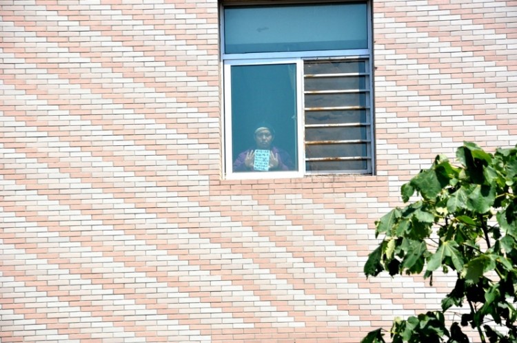 To communicate with his brother, Li Jinlong shows a placard from a hallway window on the third floor of the Chaoyang District Mental Hospital. (Photo provided by Li Jinping) To communicate with his brother, Li Jinlong shows a placard from a hallway window on the third floor of the Chaoyang District Mental Hospital. (Photo provided by Li Jinping)