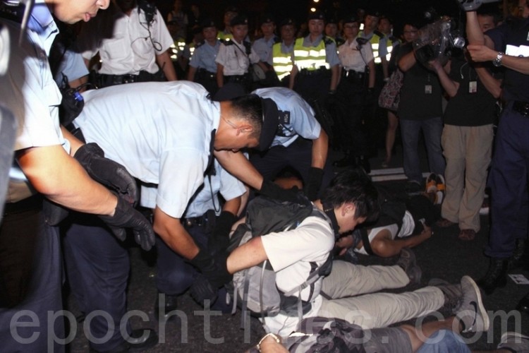 Riot police handcuff a demonstrator after the July 1, 2011 protest march in Hong Kong. (Cai Wenwen/The Epoch Times) Riot police handcuff a demonstrator after the July 1, 2011 protest march in Hong Kong. (Cai Wenwen/The Epoch Times)