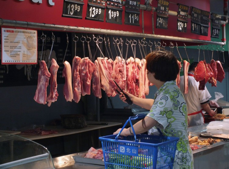 Shopper carefully selects her pork as prices have rocketed 50 percent in one year. (Chinafotopress/Getty Images) Shopper carefully selects her pork as prices have rocketed 50 percent in one year. (Chinafotopress/Getty Images)