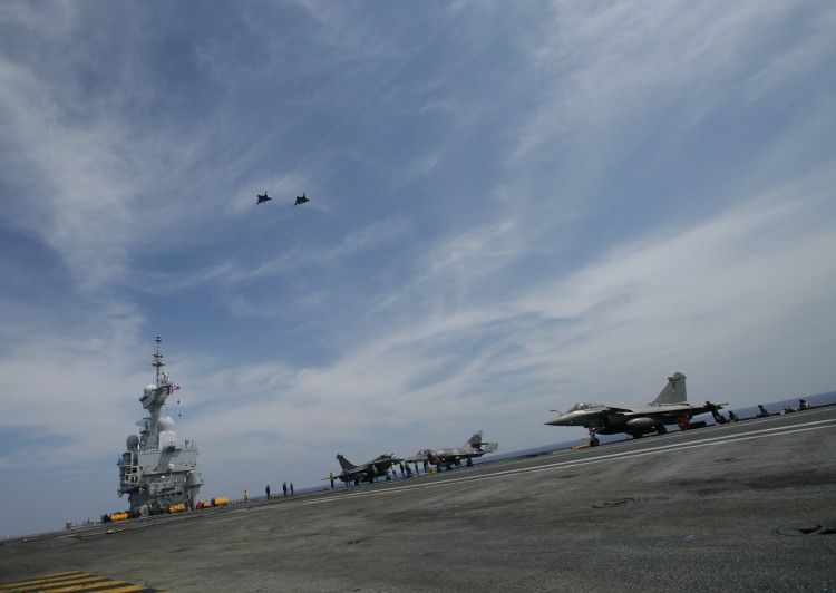 Two French Navy Rafale jet fighters fly above the Charles de Gaulle aircraft carrier on the final part of their landing, on April 21, 2011 in the Mediteranean sea. (Alexander Klein/AFP/Getty Images) Two French Navy Rafale jet fighters fly above the Charles de Gaulle aircraft carrier on the final part of their landing, on April 21, 2011 in the Mediteranean sea. (Alexander Klein/AFP/Getty Images)