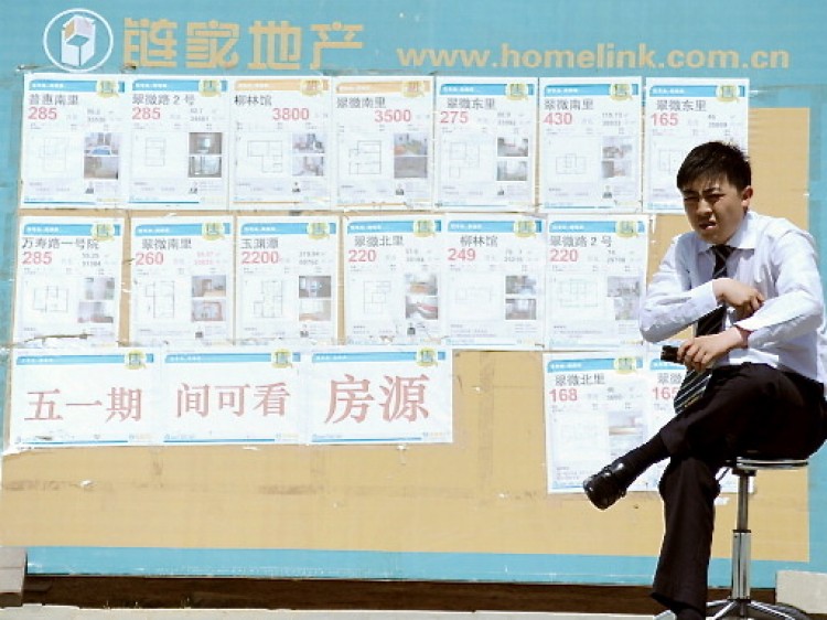 A property agent sitting in front of a board posting various property sales as he waits for house buyers by a street in Beijing. (Gou Yige/AFP/Getty Images) A property agent sitting in front of a board posting various property sales as he waits for house buyers by a street in Beijing. (Gou Yige/AFP/Getty Images)