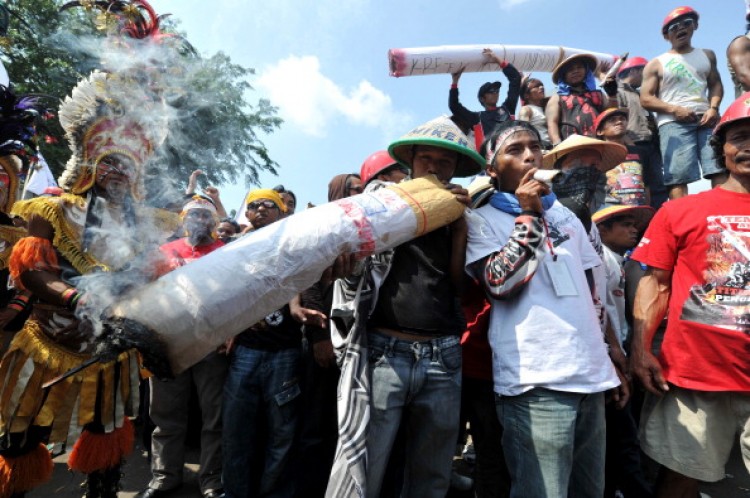 Indonesian tobacco farmers protest in Jakarta on July 13, 2011 against a new law which would ban cigarette advertising and sponsorship, prohibit smoking in public and add graphic images to packaging. Around 30 percent of Indonesians above the age of 10 smoke an average of 12 cigarettes a day, according to a 2008 report. And cigarettes are cheap at less than a dollar a pack. According to the World Health Organisation, smoking rates have risen six-fold in Indonesia over the last 40 years. Smoking kills at least 400,000 people every year and another 25,000 die from passive smoking. ( Adek Berry/AFP/Getty Images) Indonesian tobacco farmers protest in Jakarta on July 13, 2011 against a new law which would ban cigarette advertising and sponsorship, prohibit smoking in public and add graphic images to packaging. Around 30 percent of Indonesians above the age of 10 smoke an average of 12 cigarettes a day, according to a 2008 report. And cigarettes are cheap at less than a dollar a pack. According to the World Health Organisation, smoking rates have risen six-fold in Indonesia over the last 40 years. Smoking kills at least 400,000 people every year and another 25,000 die from passive smoking. ( Adek Berry/AFP/Getty Images)