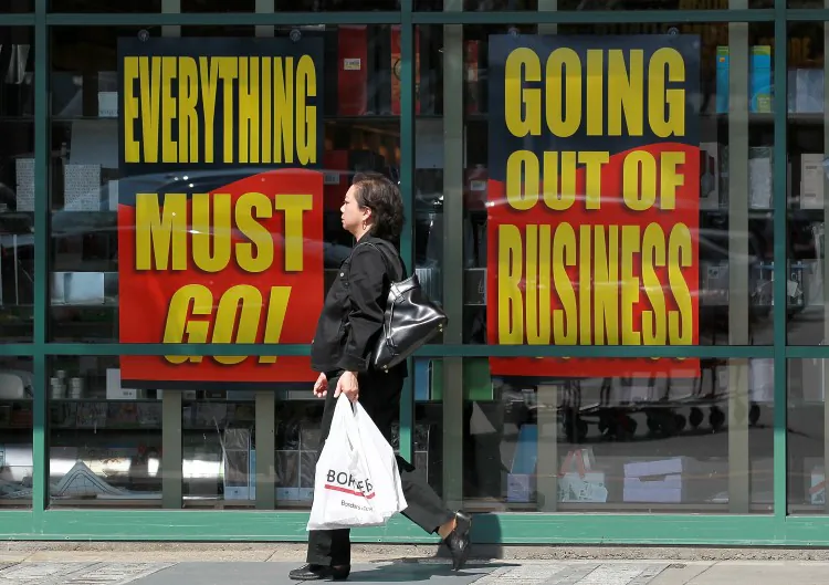 A customer walks by signs advertising a going-out-of-business sale in a file photo. (Justin Sullivan/Getty Images)