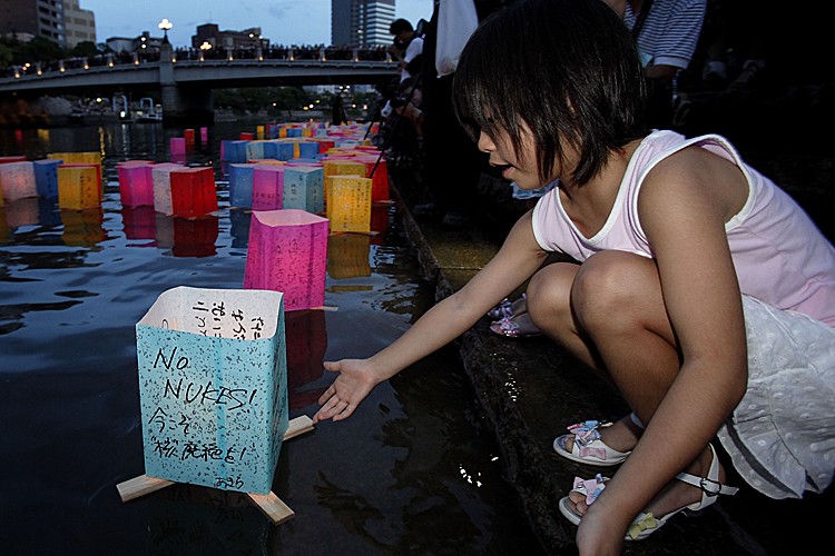 A girl releases a paper lantern onto the Motoyasu River on the 66th anniversary of the Hiroshima atomic bombing on August 6, 2011 in Hiroshima, Japan. The world's first atomic bomb was dropped on Hiroshima on August 6, 1945 by the United States during World War II, killing an estimated 70,000 people instantly with many thousands more dying over the following years from the effects of radiation. Three days later another atomic bomb was dropped on Nagasaki. (Kiyoshi Ota/Getty Images)