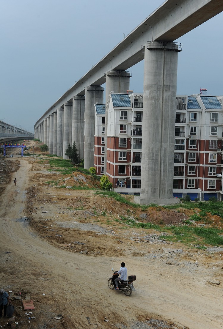 Residential buildings sitting between concrete supports of a high-speed train line in Shuandun county, in Hefei, in east China's Anhui province. (STR/AFP/Getty Images)