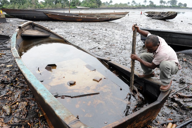 An indigene of Bodo, Ogoniland region in Rivers State, tries to separate with a stick the crude oil from water in a boat at the Bodo waterways polluted by oil spills attributed to Shell equipment failure August 11, 2011. The Bodo community in the oil-producing Niger Delta region sued Shell oil company in the United Kingdom, alleging that spills in 2008 and 2009 had destroyed the environment and ruined their livelihoods. The UN released a report this month saying decades of oil spills in the Nigerian region of Ogoniland may require the biggest cleanup ever undertaken, with communities dependent upon farmers and fishermen left ravaged. (Pius Utom Ekpei/AFP/Getty Images)