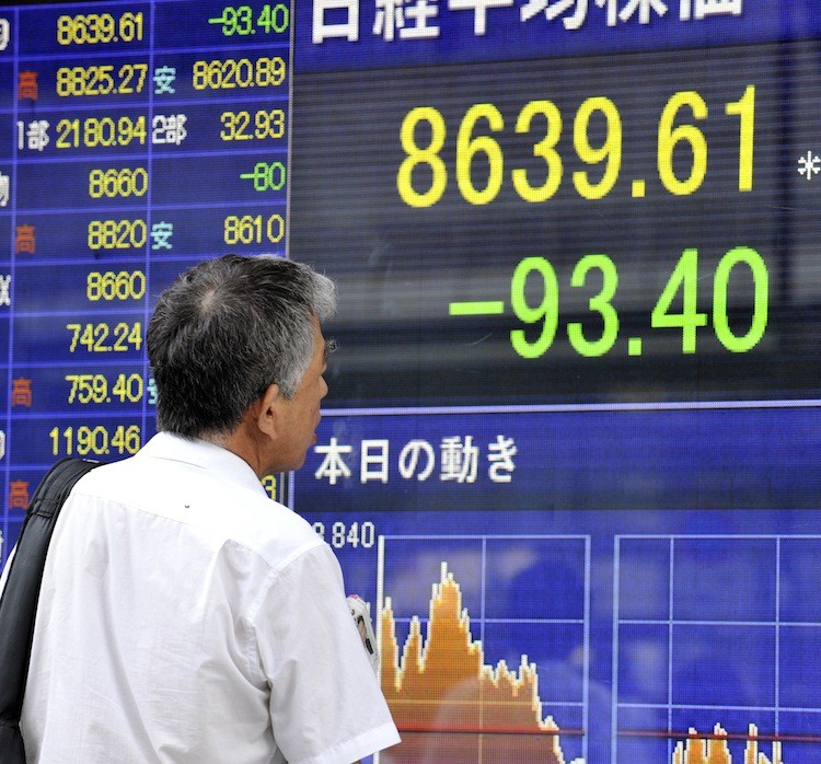 DOWNGRADED: A businessman looks at a share prices board in Tokyo on August 24. Japan's share prices fell 93.40 points to close at 8,639.61 at the Tokyo Stock Exchange as a downgrade of Japanese sovereign debt and banks by ratings agency Moody's affected the downturn.  (Yoshikazu Tsuno/Getty Images)