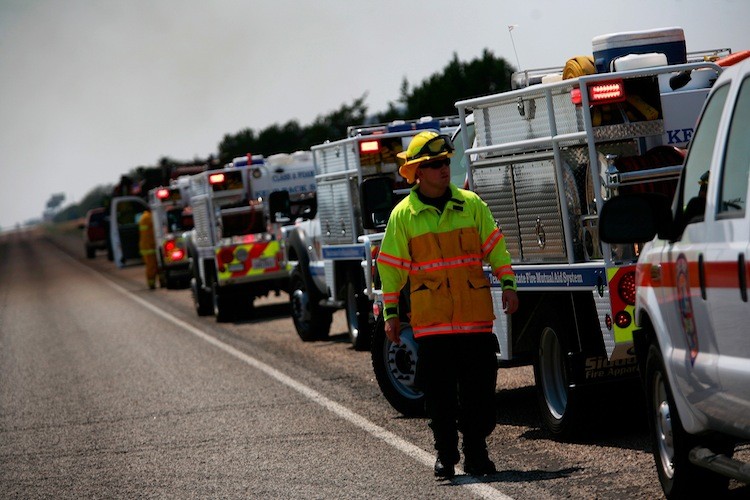 WILDFIRES: Firefighters stage along Highway 16 while fighting a wildfire on Sept. 1 in Graford, Texas. The Texas Forest Service (TFS) have responded to 63 new fires that have burned approximately 32,936 acres. (Tom Pennington/Getty Images) WILDFIRES: Firefighters stage along Highway 16 while fighting a wildfire on Sept. 1 in Graford, Texas. The Texas Forest Service (TFS) have responded to 63 new fires that have burned approximately 32,936 acres. (Tom Pennington/Getty Images)
