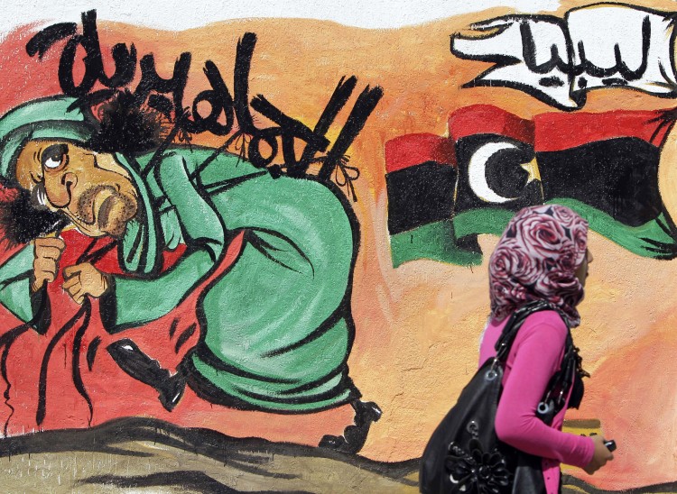 A Libyan woman walks past graffiti depicting ousted Libyan leader Moammar Gadhafi at a street in Tripoli on September 27, 2011. (Joseph Eid/AFP/Getty Images) A Libyan woman walks past graffiti depicting ousted Libyan leader Moammar Gadhafi at a street in Tripoli on September 27, 2011. (Joseph Eid/AFP/Getty Images)