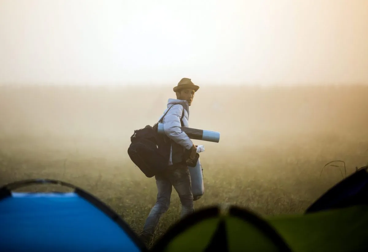 A migrant leaves the camp and walks through a field to avoid checkpoints along the railway tracks connecting Horgos and Szeged near Roszke, Hungary, at the Hungarian-Serbian border, on Sept. 13, 2015. (Balazs Mohai/MTI via AP)